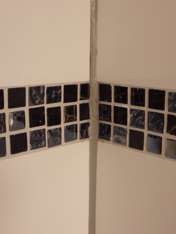 schwarze-mosaikfliesen-bad-wand-ecke.JPG