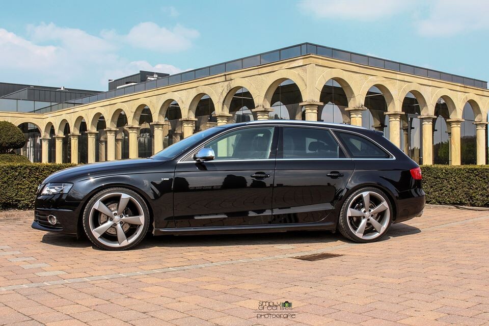 Schwarzes Auto vor Arkaden-Gebäude aus Stein, moderner Gebäudestil