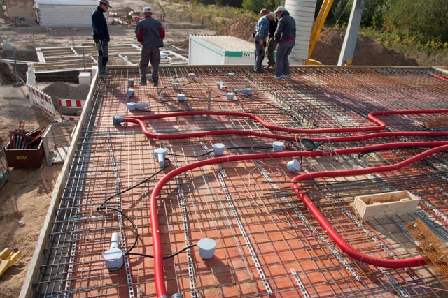 sichtbare-bewehrung-und-rohrleitungen-auf-bau-fundament-mitarbeiter-auf-der-baustelle.jpg