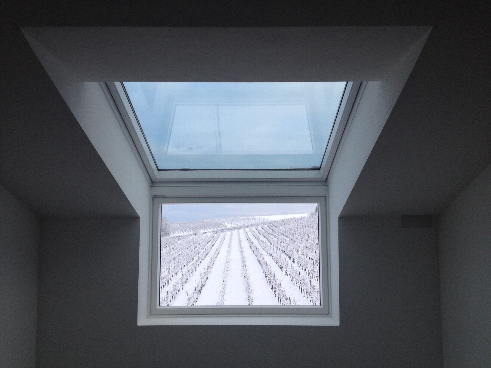 Skylightfenster im Innenraum mit Blick auf verschneite Landschaft