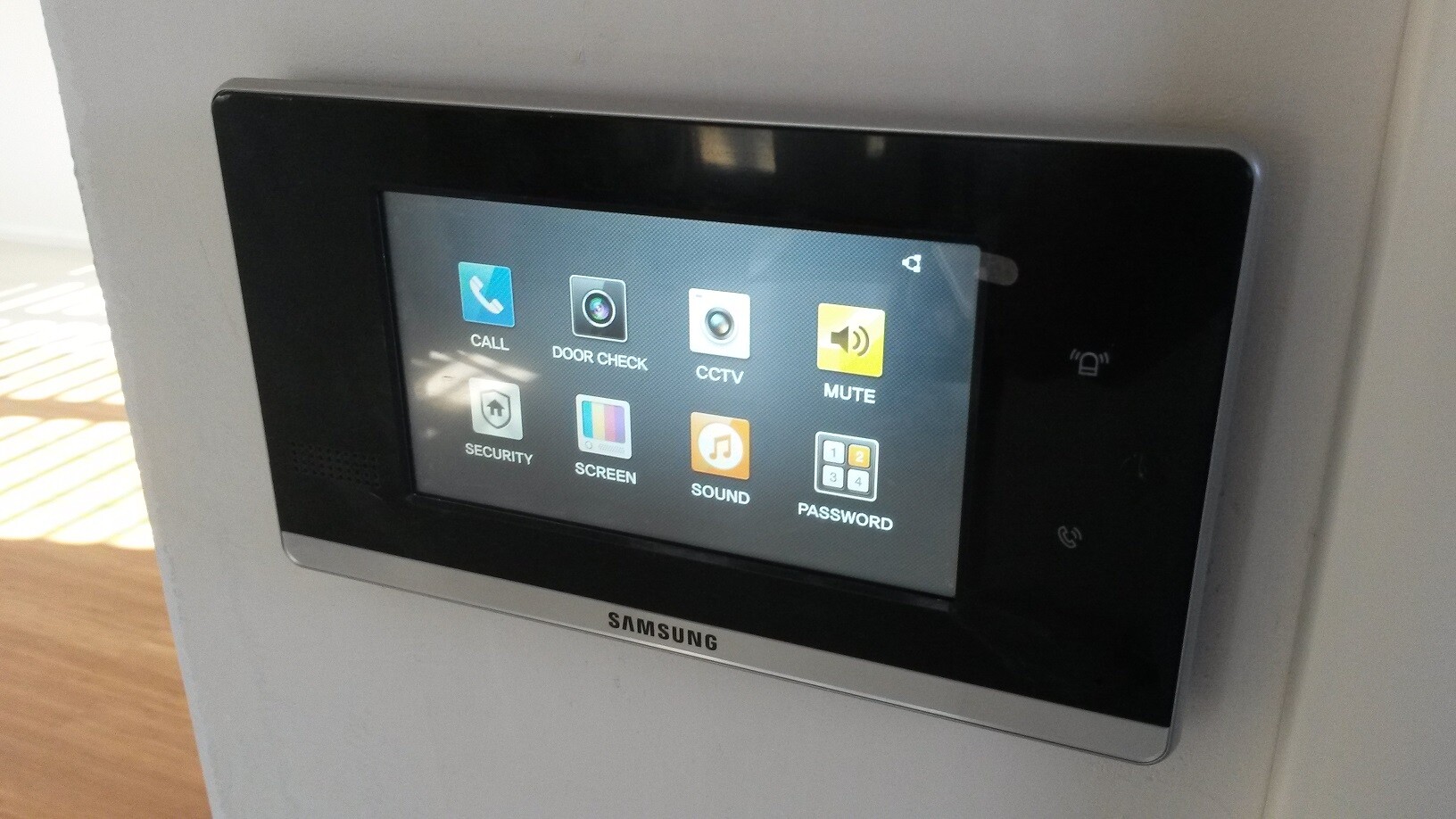 Wandpanel mit Touchscreen und Icons: CALL, DOOR CHECK, CCTV, MUTE, SECURITY, SCREEN, SOUND