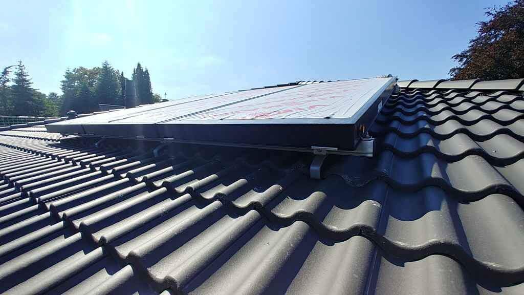 Dach mit dunkelgrauen Ziegeln und installiertem Solarpanel