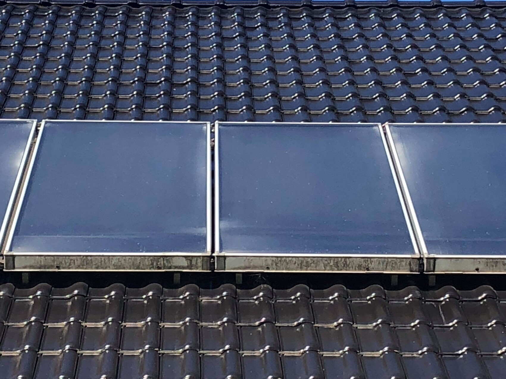 Dach mit blauen Solarmodulen auf Ziegeldach installiert