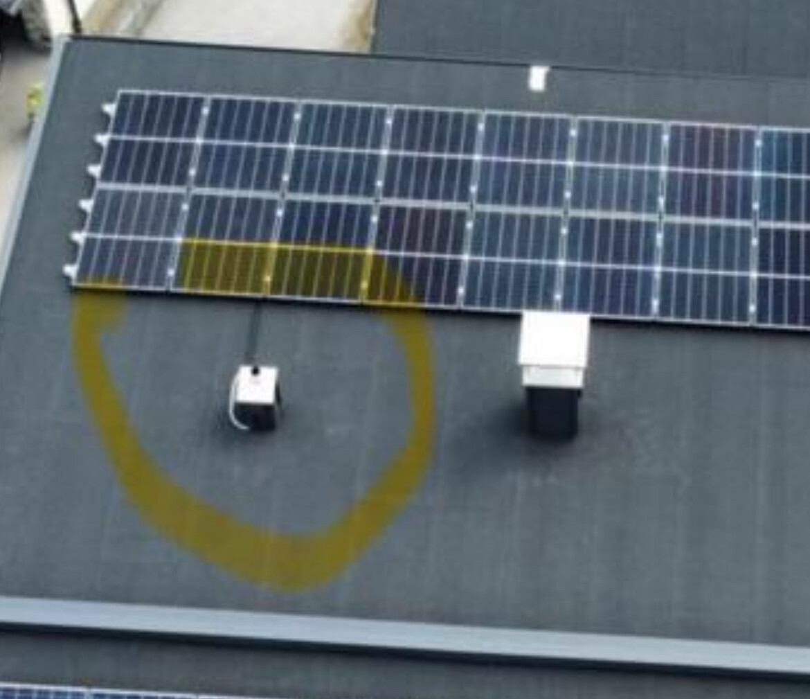 Dach mit Solarmodulen; gelbe Kreismarkierung hebt eine kleine Box auf dem Dach hervor.