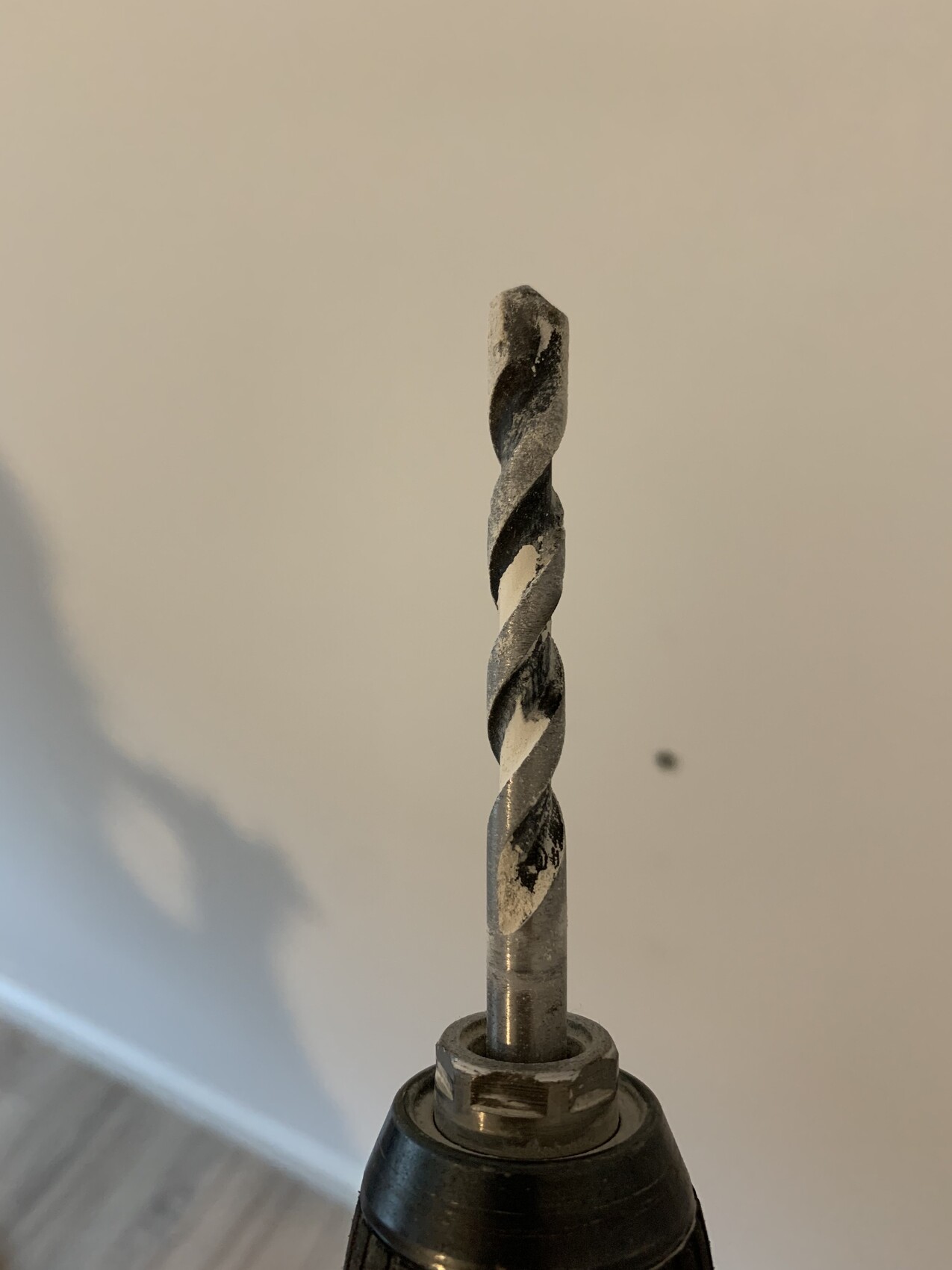 Nahaufnahme eines Spiralbohrers im Bohrfutter, staubig.