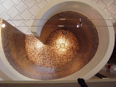 Runde spiralförmige Treppe mit mosaikfliesen im Treppenhaus von oben