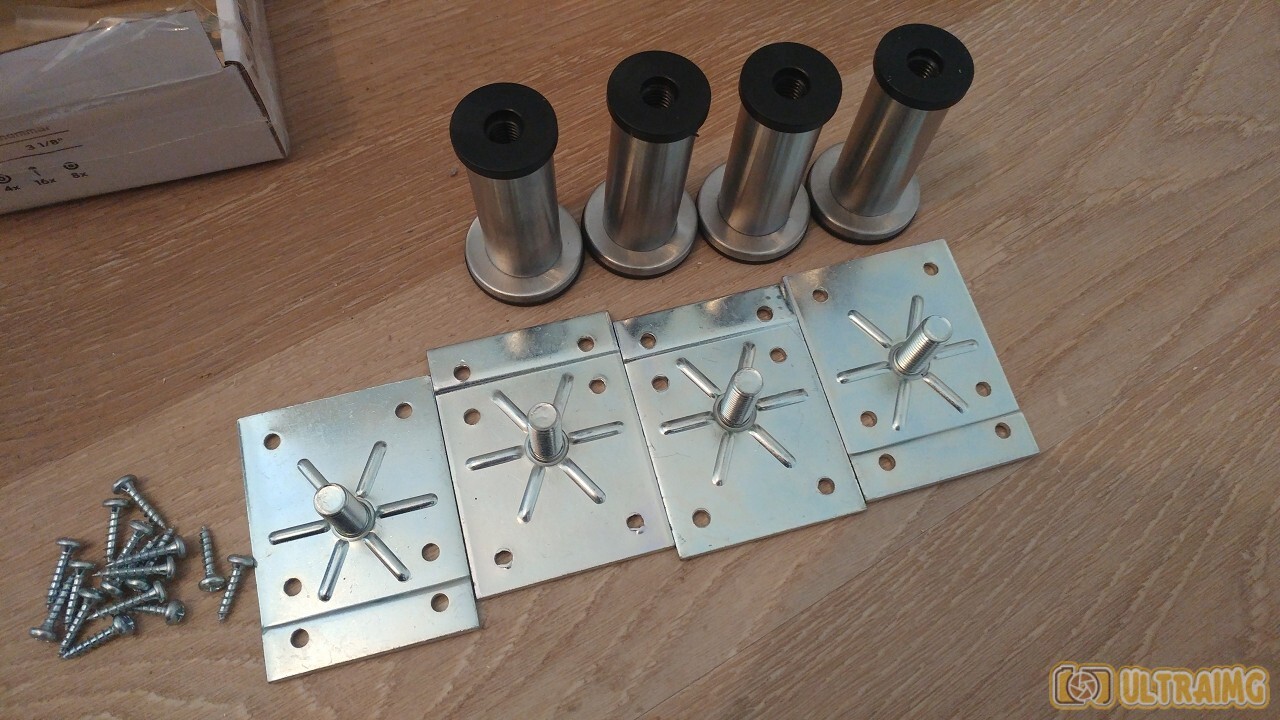 Vier Metallplatten mit Zentralbolzen, Schrauben links, Spindel-Spacer oben auf Holzboden