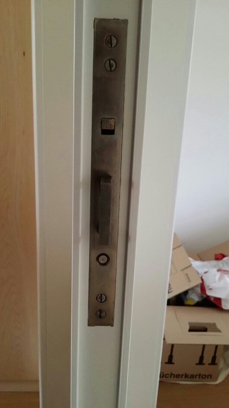 Türbeschlag aus Metall am Türrahmen mit Griff, Schrauben sichtbar