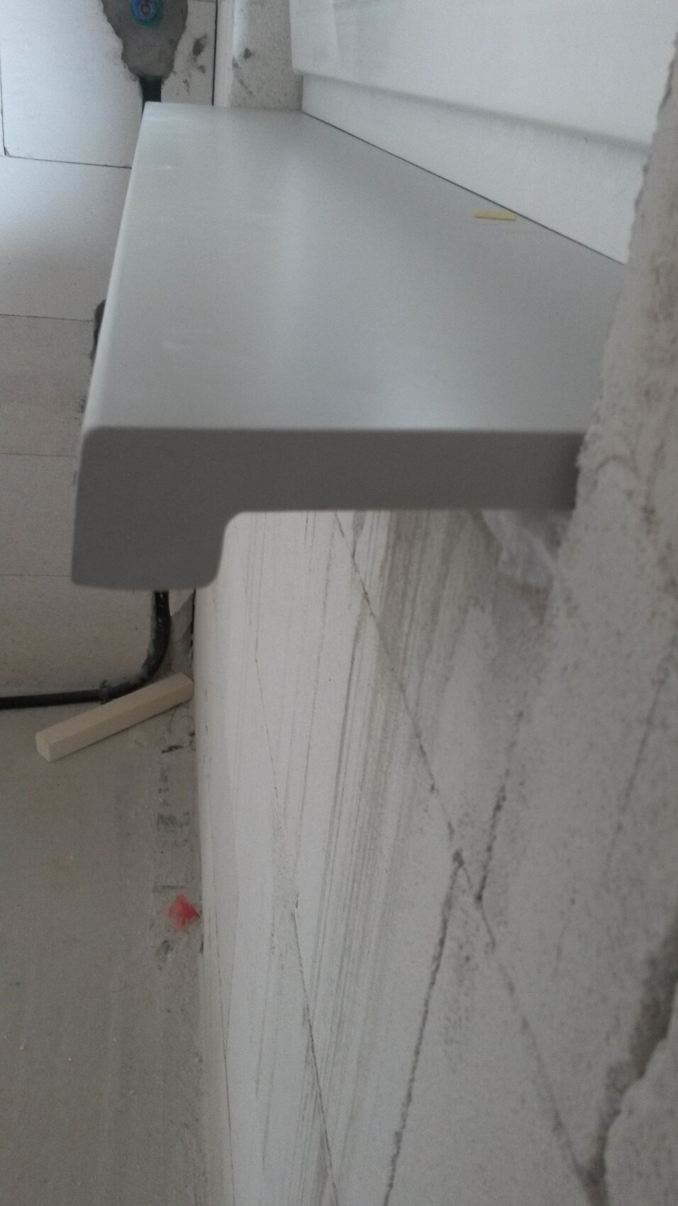 Stahlablage vor Betonwand auf Baustelle, Innenausbau