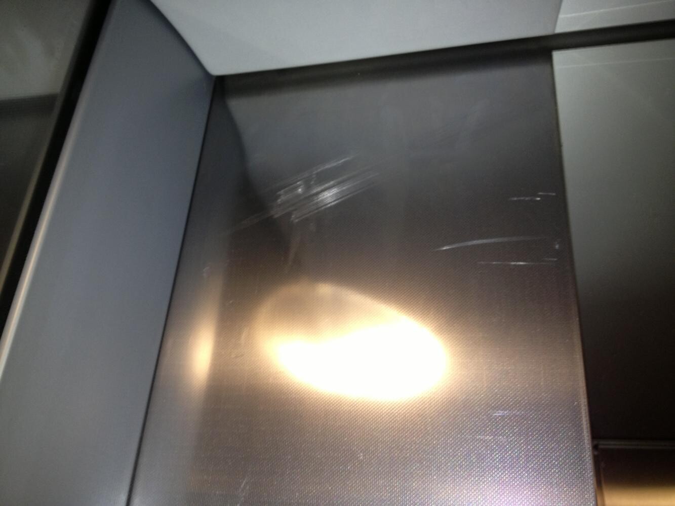 Stählerne Innenfläche mit Kratzern und Lichtreflexen