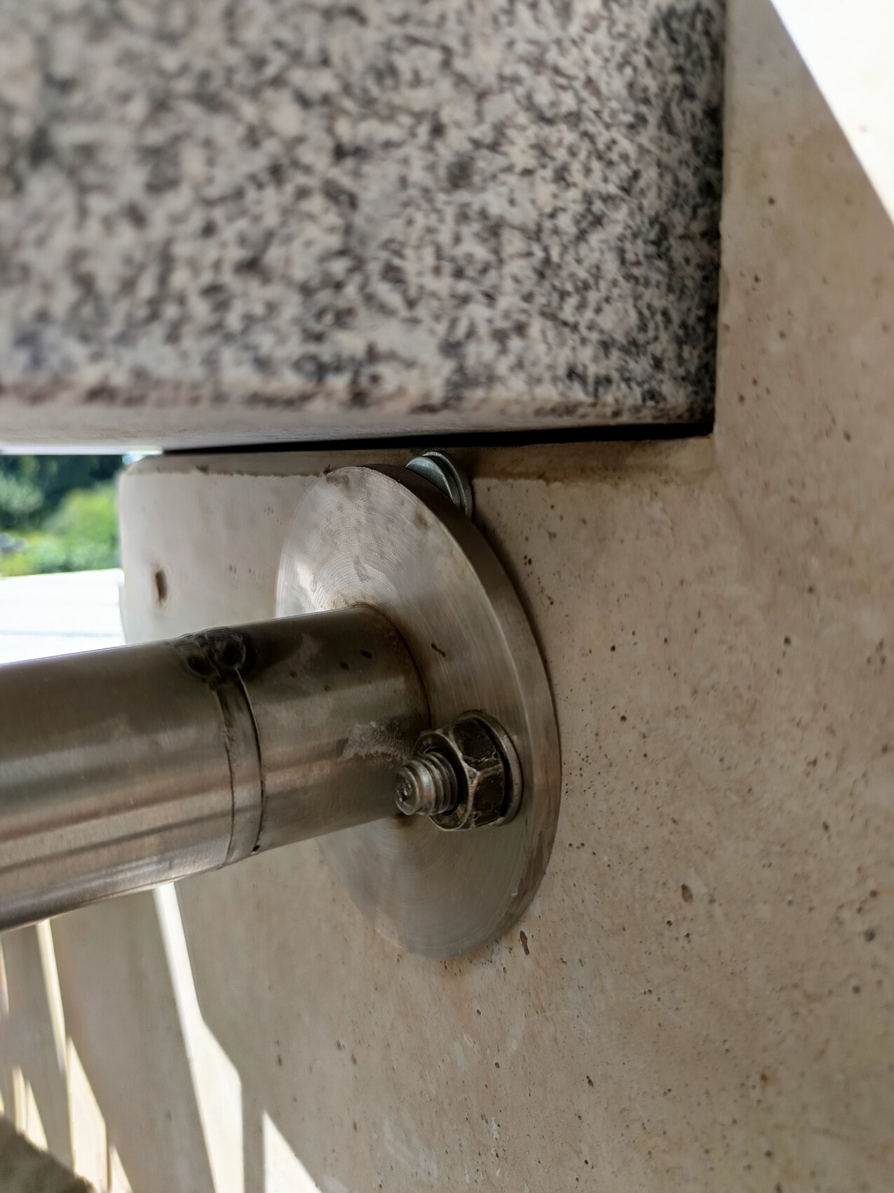 Stahlrohr mit Flansch befestigt an Betonuntergrund, Schraubverbindung sichtbar