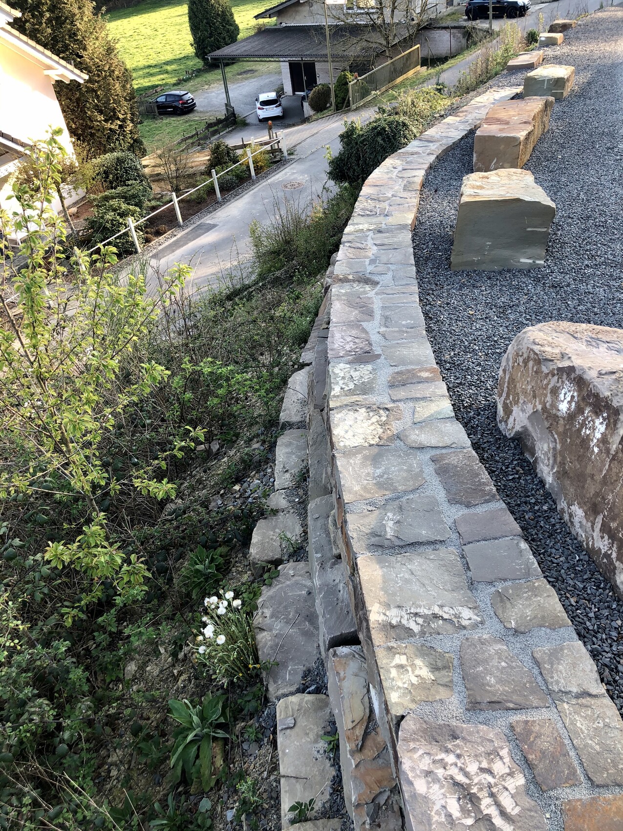 Garten mit Natursteinmauer, Kiesweg und Hanggelände