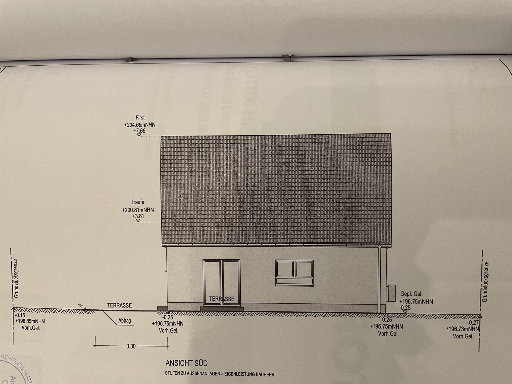 Südansicht eines Einfamilienhauses mit Satteldach, Terrasse und Fenster.