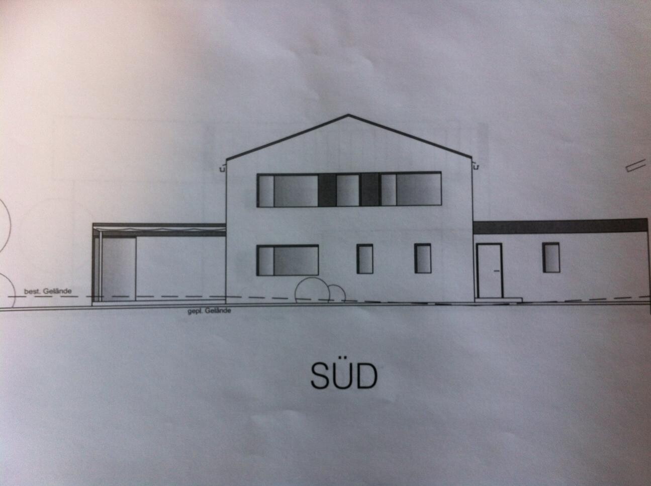 Südliche Fassadendarstellung eines mehrteiligen Hauses mit Giebeldach und Fenstern