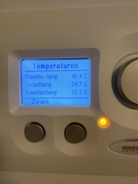 Heizungsregler mit blauem Display zeigt Temperaturwerte (Brauchw.temp, Vorlauftemp, Ruecklauftemp).