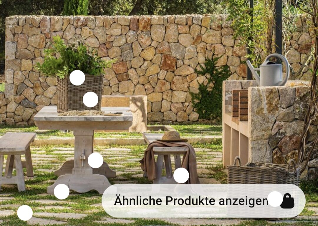 Garten im Freien: Steintisch, Steinmauer, Pflanzenkorb, Stühle, Hut und Gießkanne.