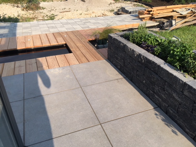 terrasse-garten-vorplatz-hellgraue-fliesen-steinmauer-holzdeck-bauarbeiten.jpeg