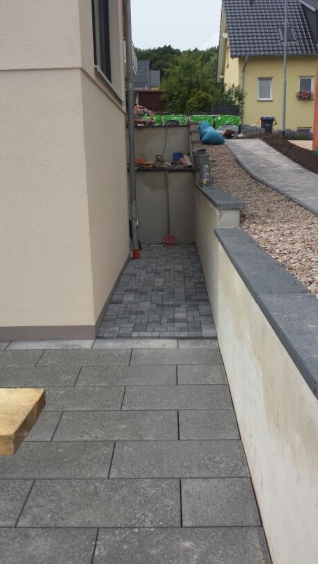 Außenbereich mit gepflastertem Weg und Vorplatz neben Wohnhaus