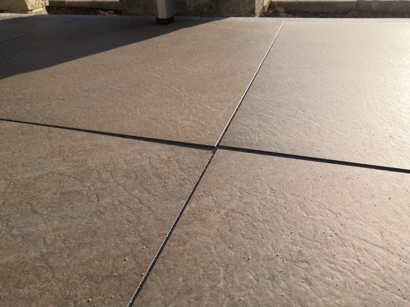 Terrassenboden aus Steinplatten mit dunkler Fuge im Freien