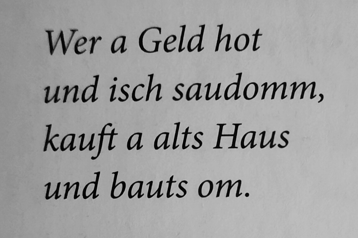 Zweizeiliger Dialekt-Spruch über Geld und Umbau eines alten Hauses.