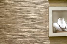 Beige texturierte Wand mit kleinem weißen Bilderrahmen und Schmuckdisplay