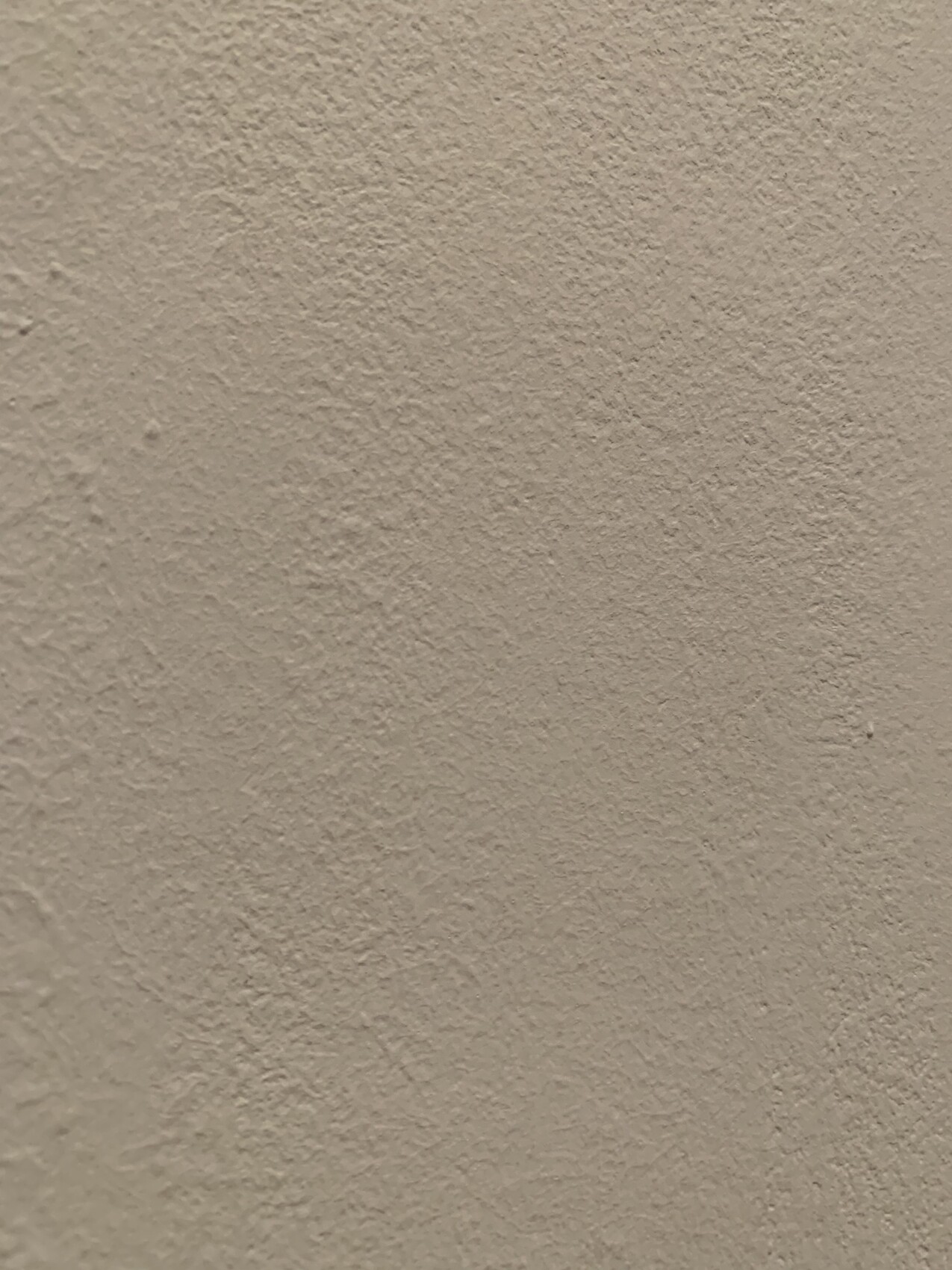 Beige, grob texturierte Putzwand; Nahaufnahme, keine Objekte zu sehen.