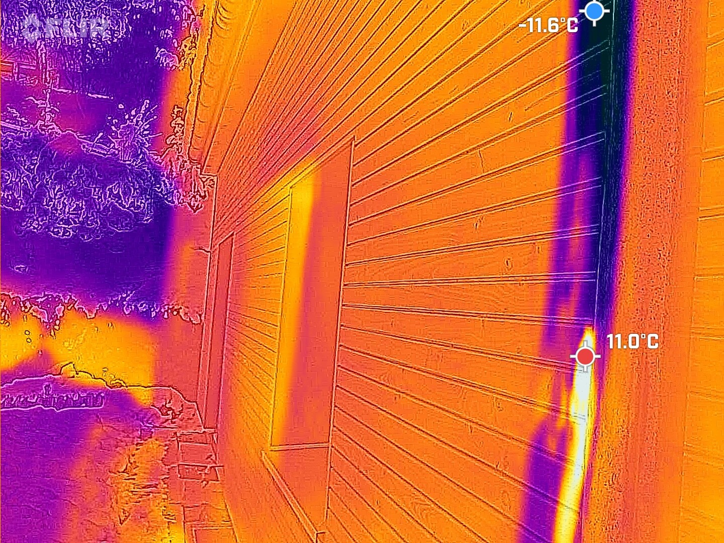 Thermografie eines Hauses mit Tür an Wand; linke Seite kalt, rechte warm, Temperaturangaben.