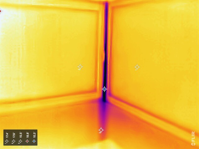 Thermografie eines Zimmereckens: gelbe Wärmeflächen, blaue Kante in der Ecke