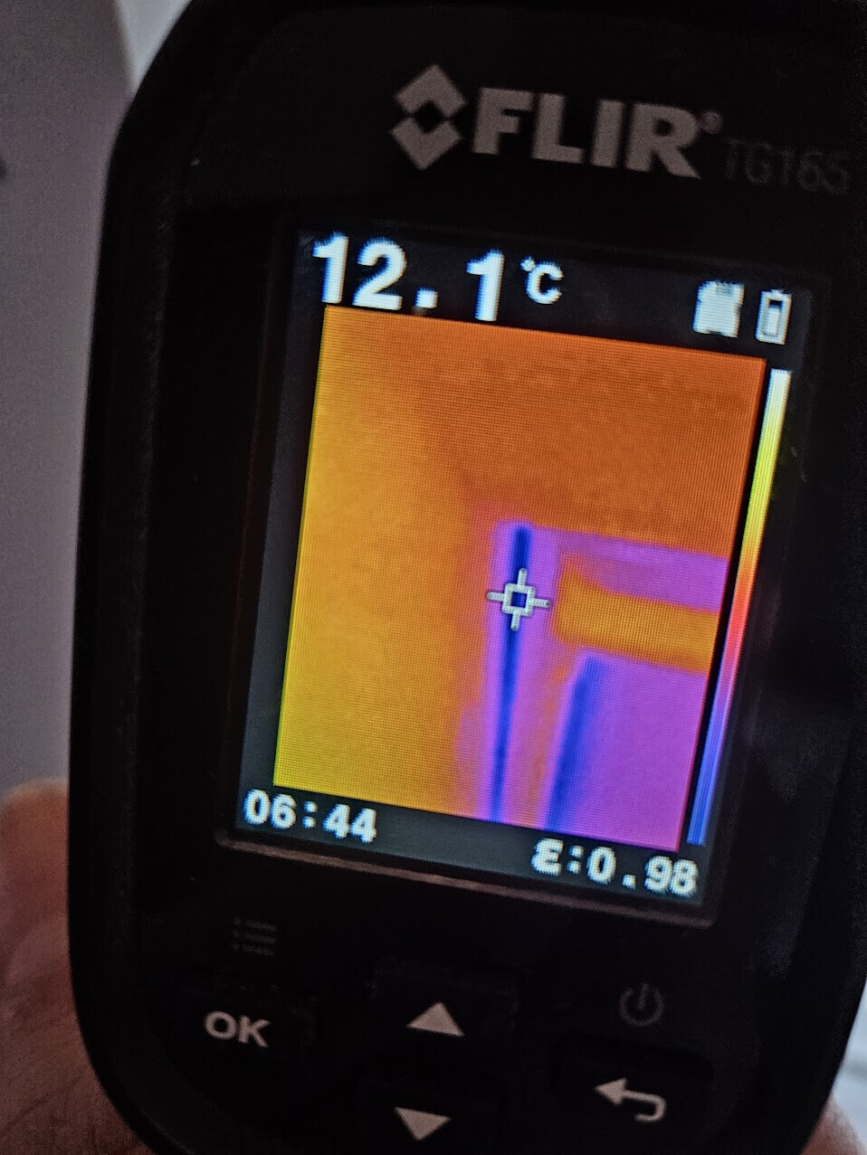 Wärmebild mit Flir-Gerät; Display zeigt 12.1 °C, gelb-orange Fläche und blaue Linien, Fadenkreuz
