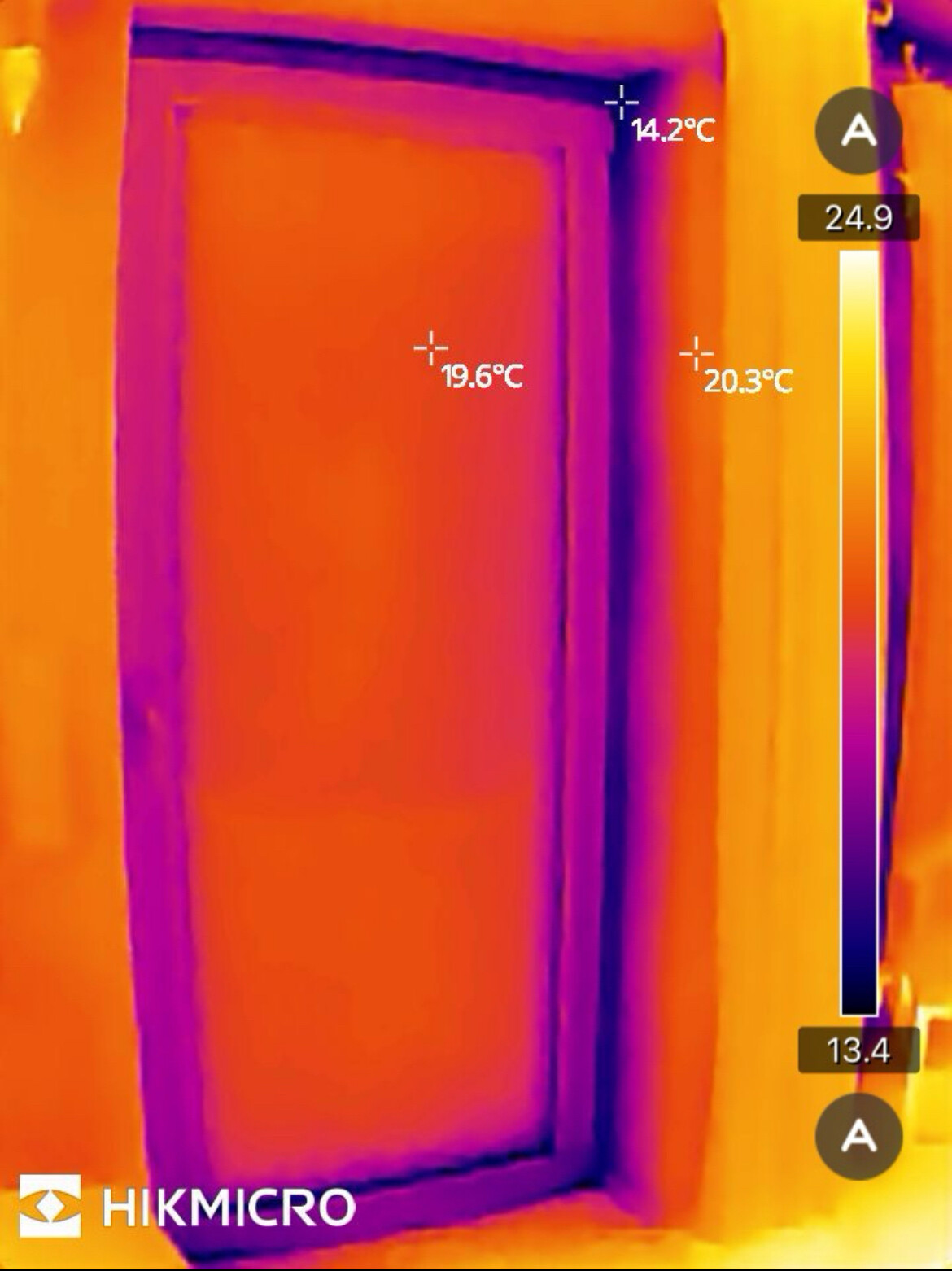 Thermische Aufnahme eines Zimmers mit Tür; warme Türfläche ca. 20–25°C, Umgebung kühler.