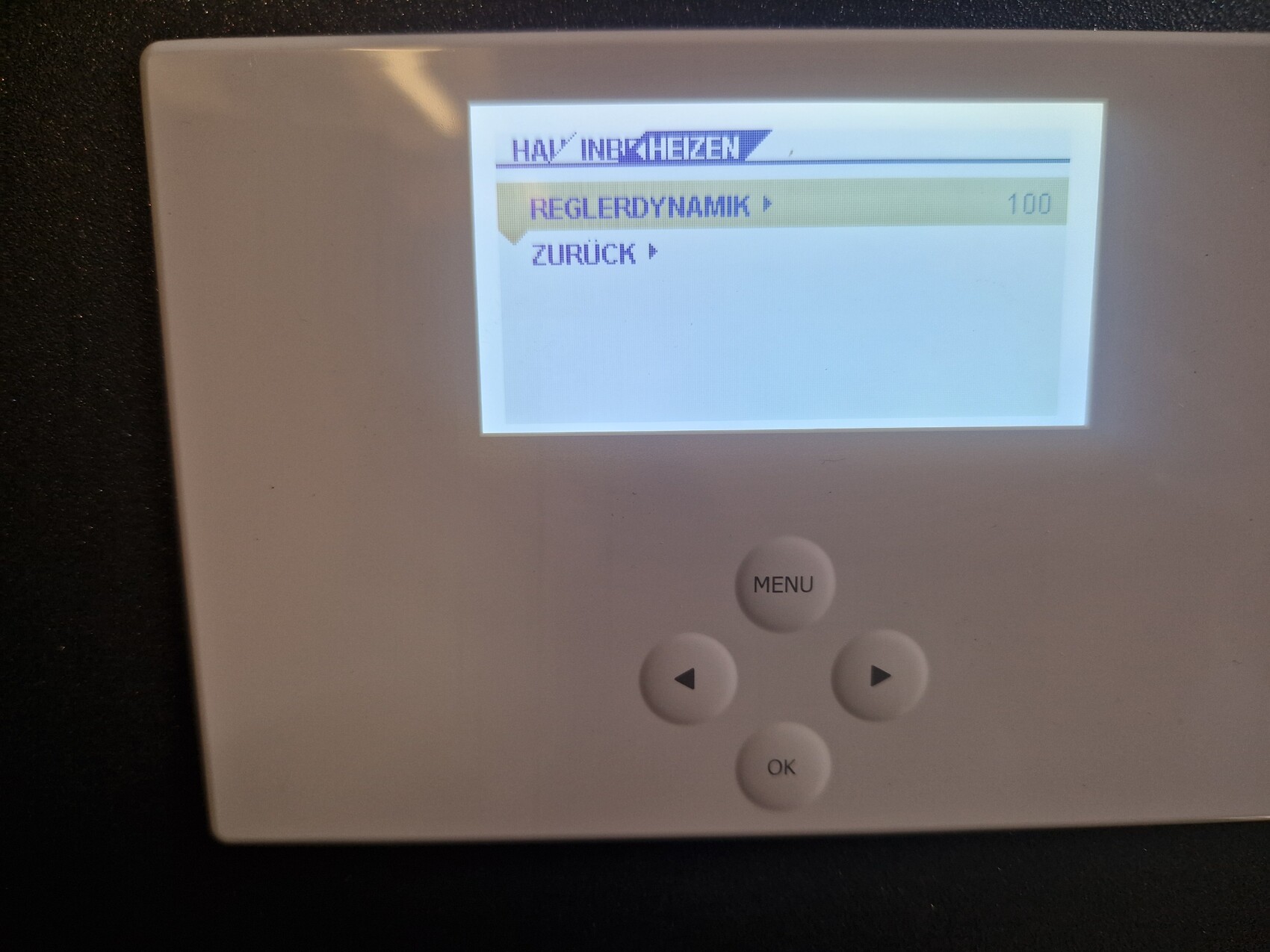 Weißes Heizungsregelgerät mit Display, Menü- und Pfeiltasten.