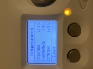 Thermostat mit blauem Display zeigt Temperaturwerte und Einstellung.