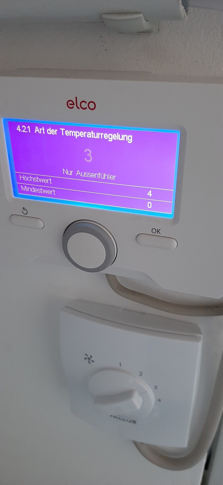 Elco Temperaturregler mit blauem Display, Außenfühleranzeige und Drehknopf.