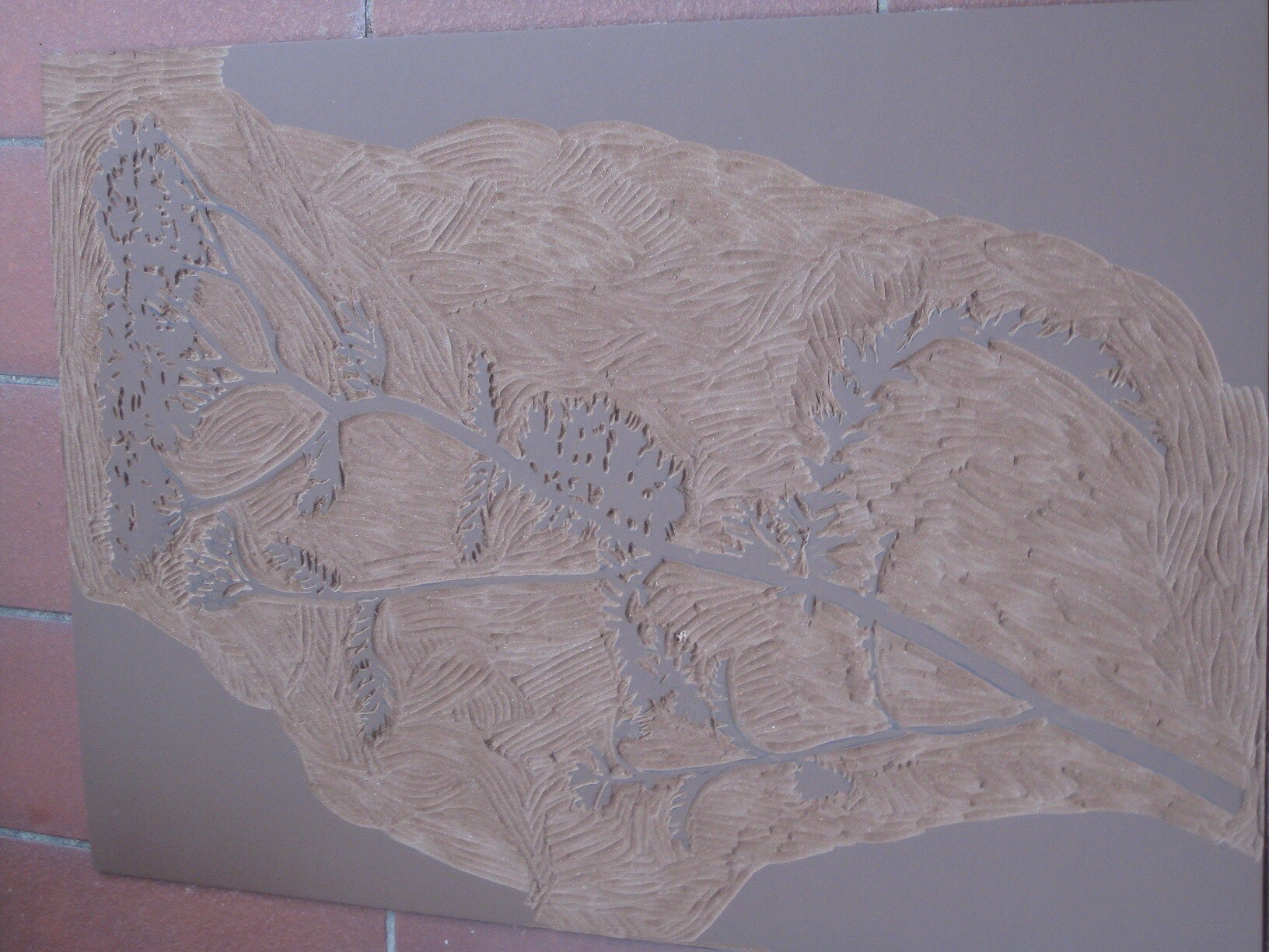 Tonrelief zeigt topografische Landkarte mit Flussverlauf und Wegen auf braunem Hintergrund