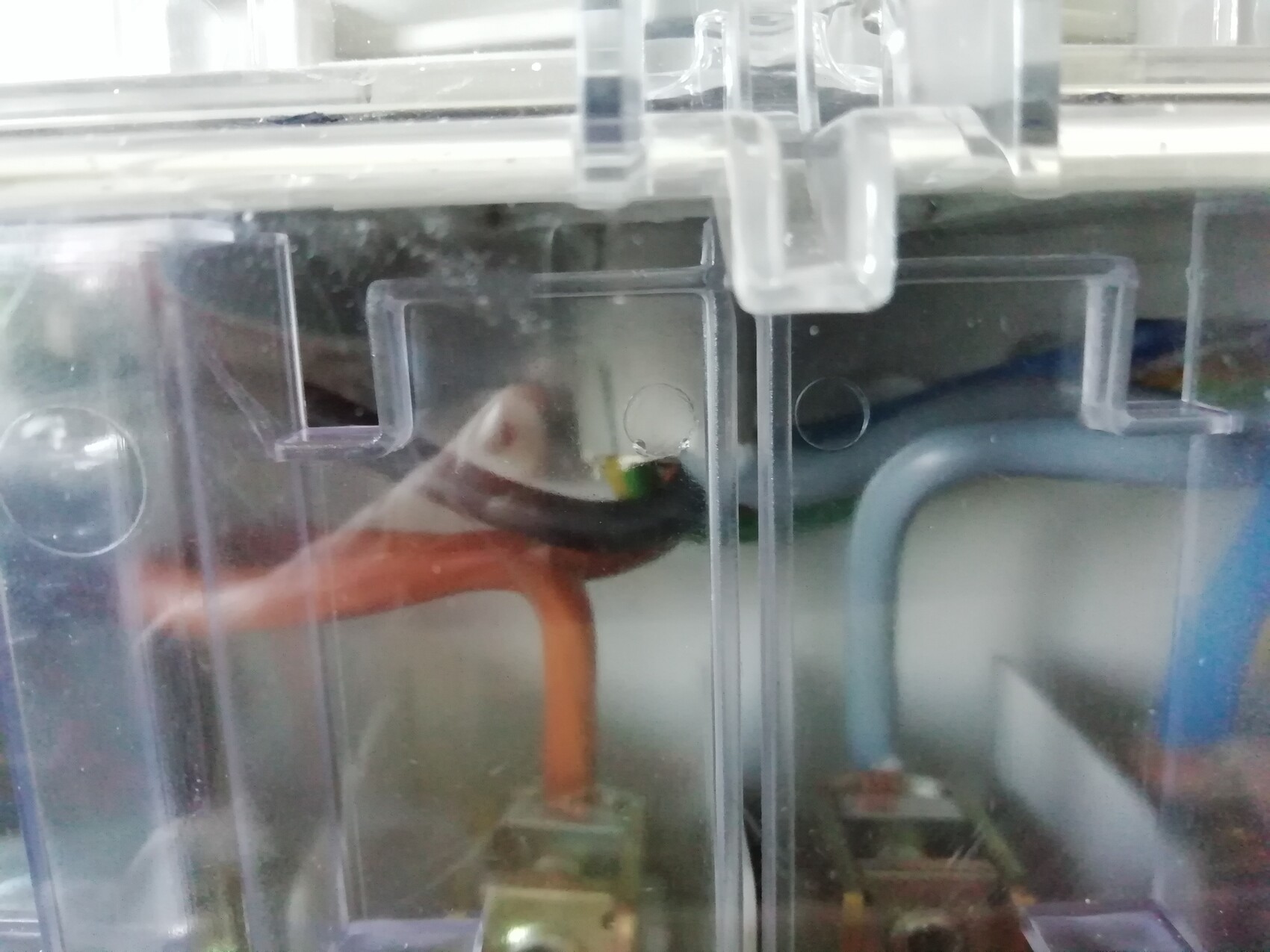 Transparentes Kunststoffgehäuse mit orangefarbenem Schlauch und sichtbaren Elektronikbauteilen.