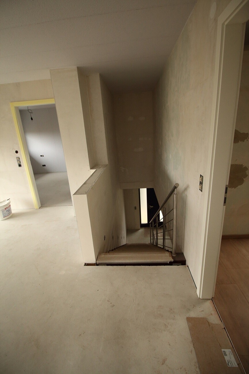 Offene Treppe in einem unfertigen Innenbereich einer Baustelle mit Geländer