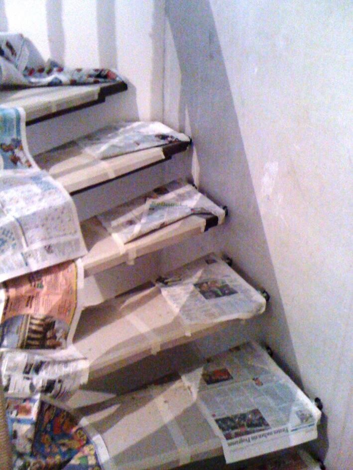 Unfertige Treppe in Bauphase, Stufen mit Zeitungspapier bedeckt