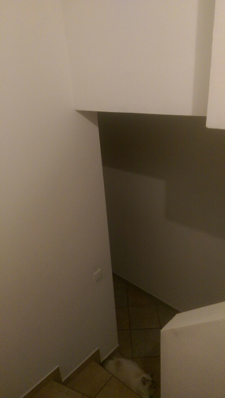 Innenansicht eines Treppenhauses mit weißen Wänden, Treppenstufen und Flur-Ecke