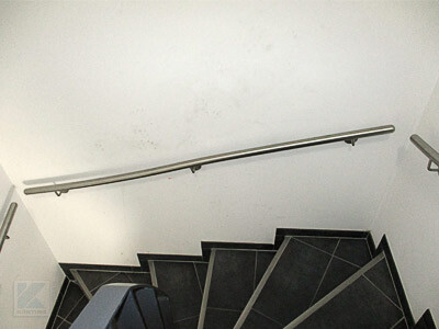 Innenbereich: Dunkle Treppe mit Metallhandlauf im Treppenhaus