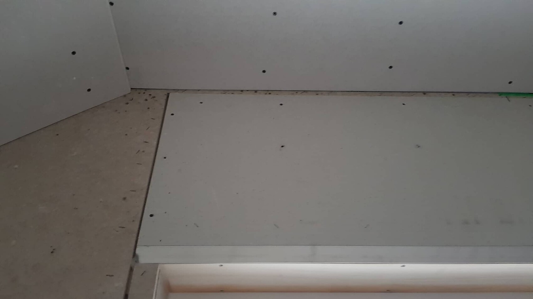 Gipskartonplatten werden an Wand und Decke montiert, Schrauben sichtbar