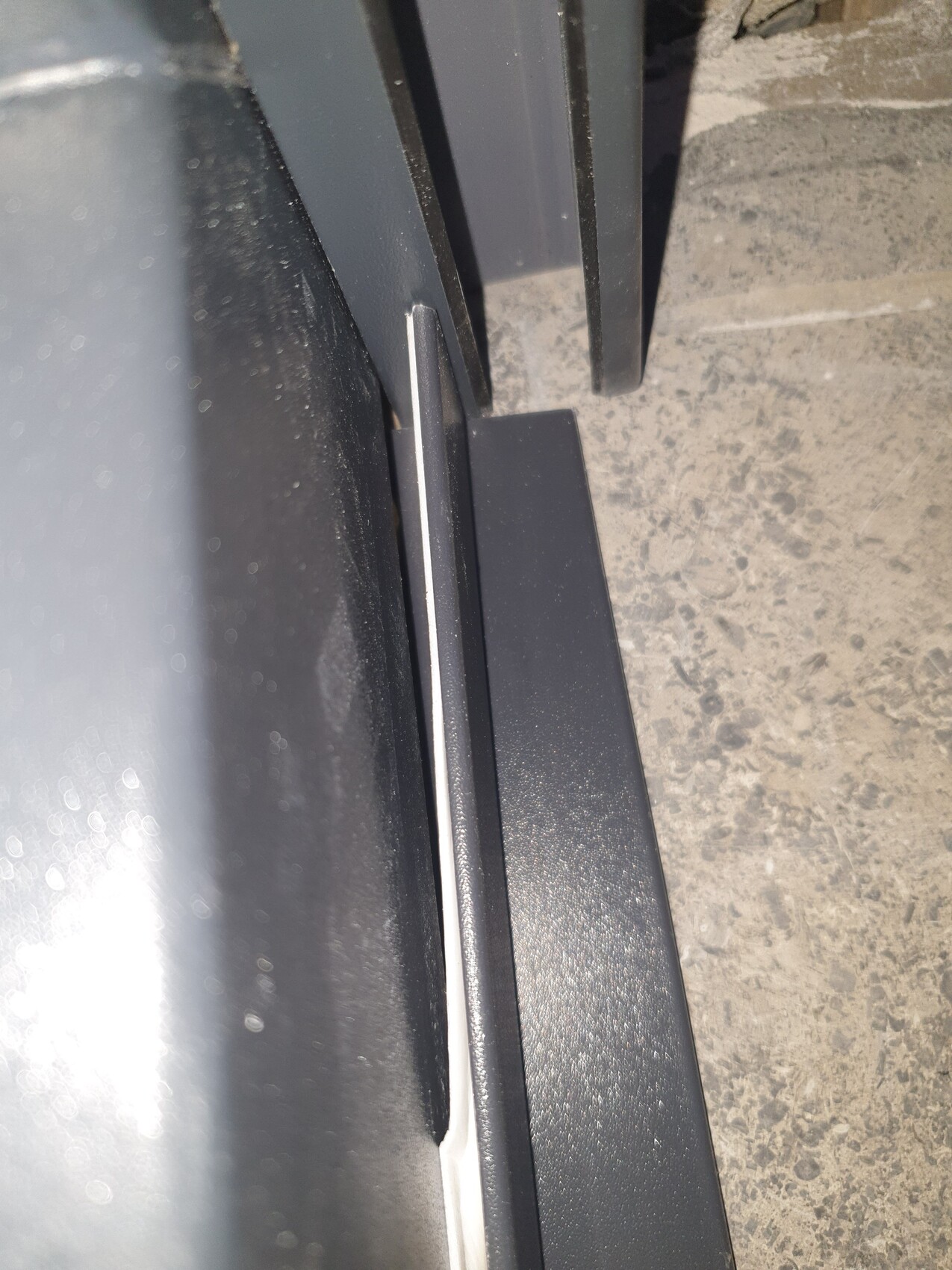Nahaufnahme des Türrahmens eines Autos mit Gummidichtung im unteren Spalt.