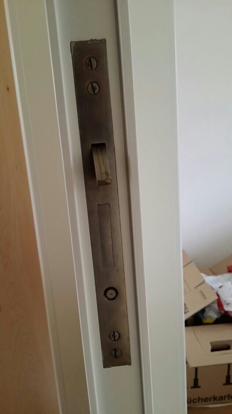 Türrahmen mit Metall-Schlossblech und Schraubplatten Nahaufnahme, Hintergrund Kartons