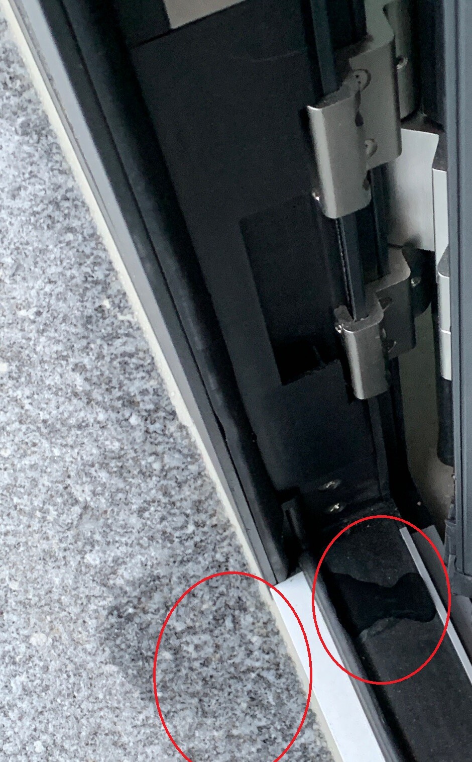 Nahaufnahme am Türrahmenboden mit Scharnier und Dichtung, Spalt sichtbar.