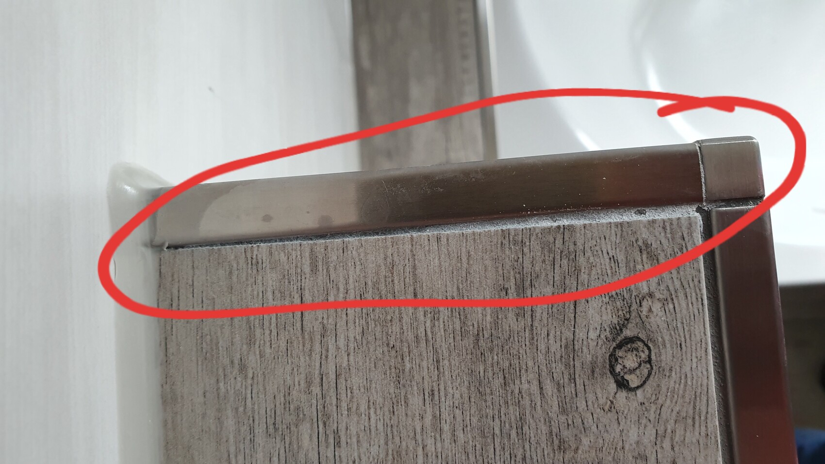 Nahaufnahme einer Holz-Türkante mit Metallprofil und roter Markierung (Scharnierbereich)