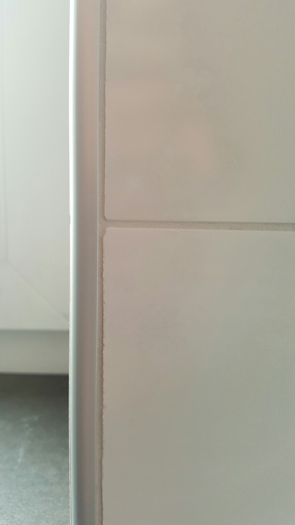 Nahaufnahme eines weißen türrahmens neben fliesen im innenbereich