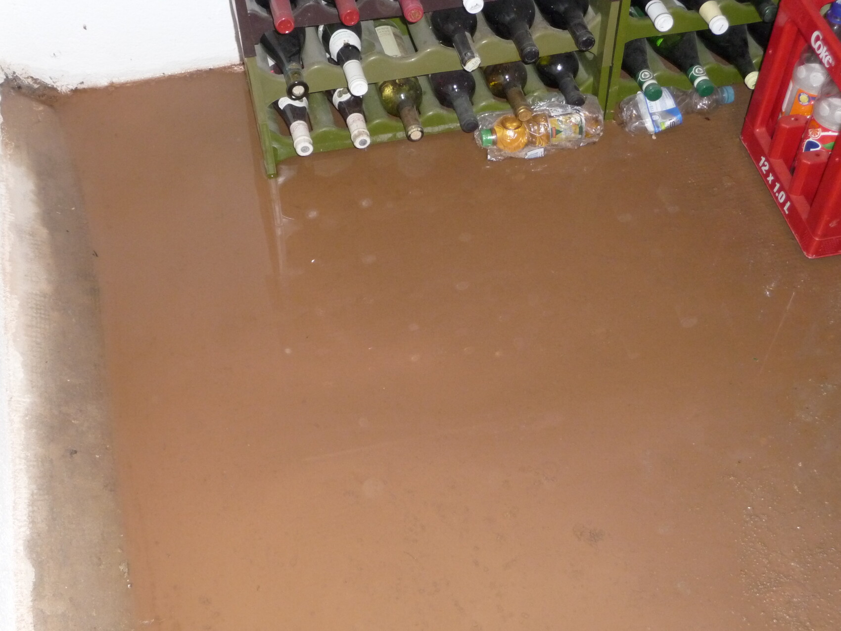 Kellerboden steht unter Wasser, Weinregal und Getränkekisten sichtbar