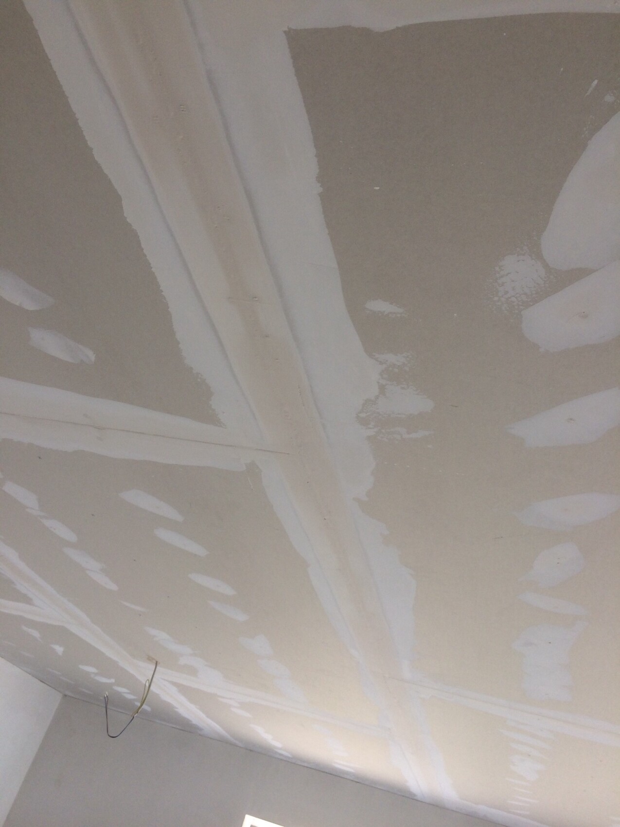 Unbearbeitete Decke mit Spachtelarbeiten und Trockenbau-Nähten bei Renovierungsarbeiten