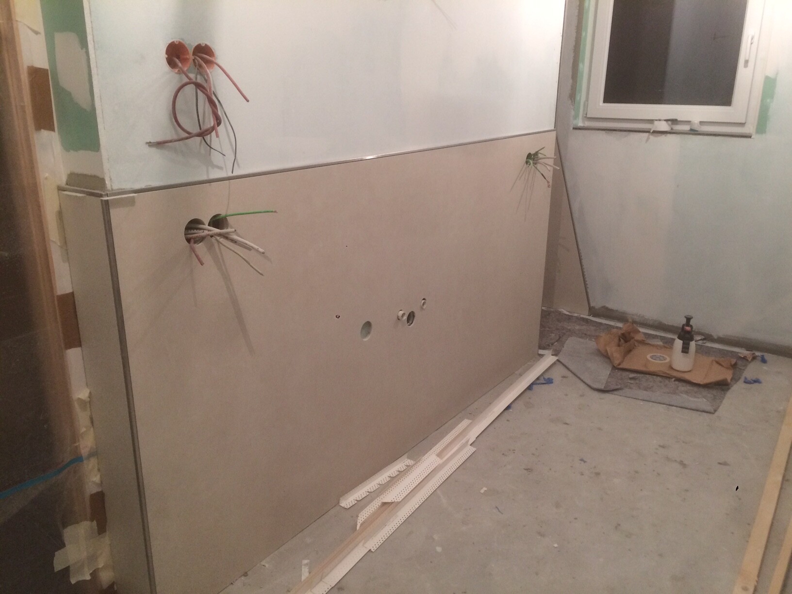Badezimmerumbau: Metallwandverkleidung, offene Kabel und Werkzeuge liegen am Boden.