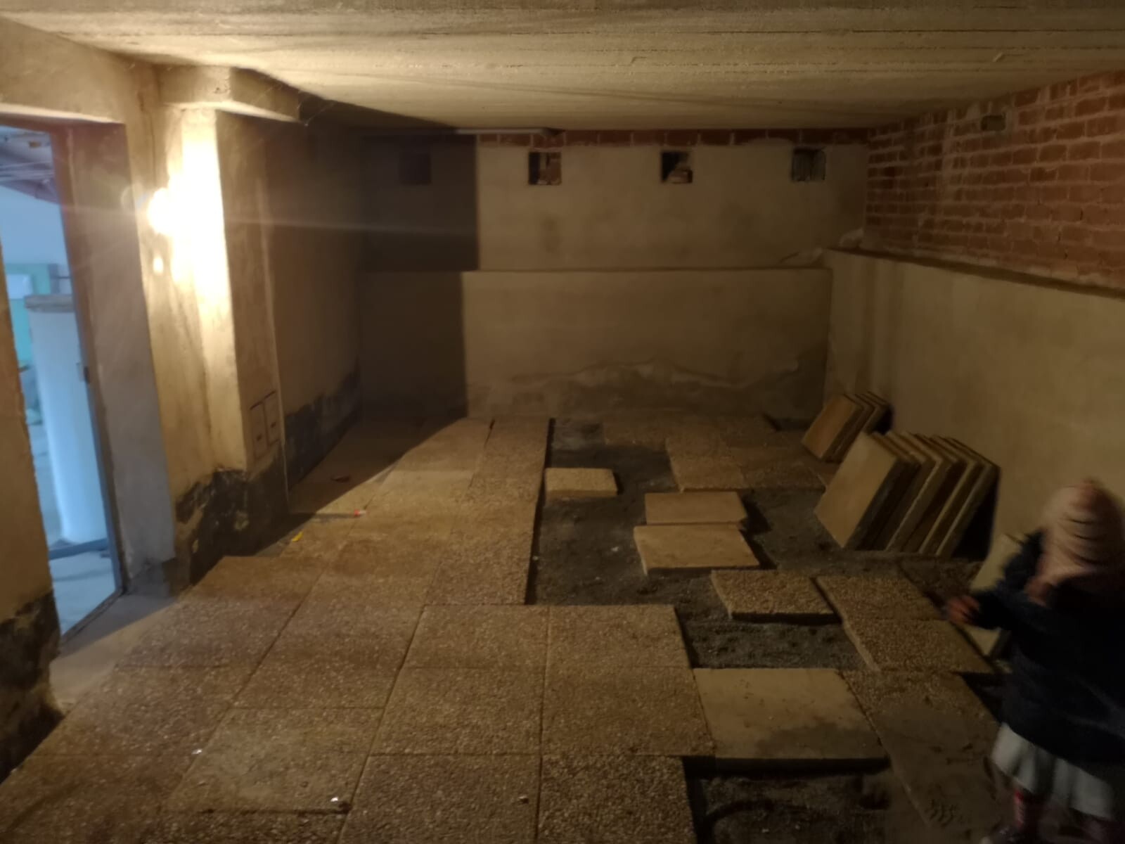 Unfertige Kellerbaustelle mit Betonwänden, Ziegeln und Bodenplatten
