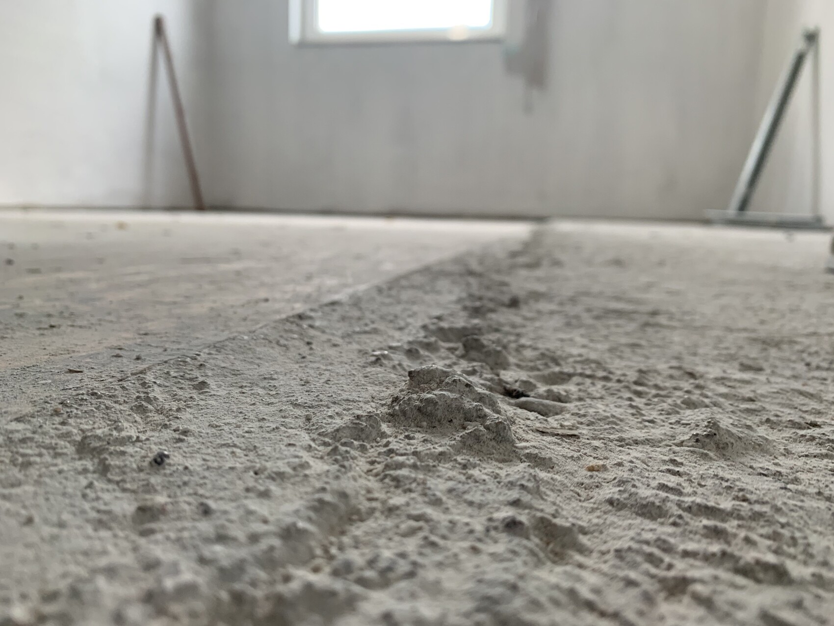Unfertiger Innenraum mit rauem Betonboden auf Baustelle